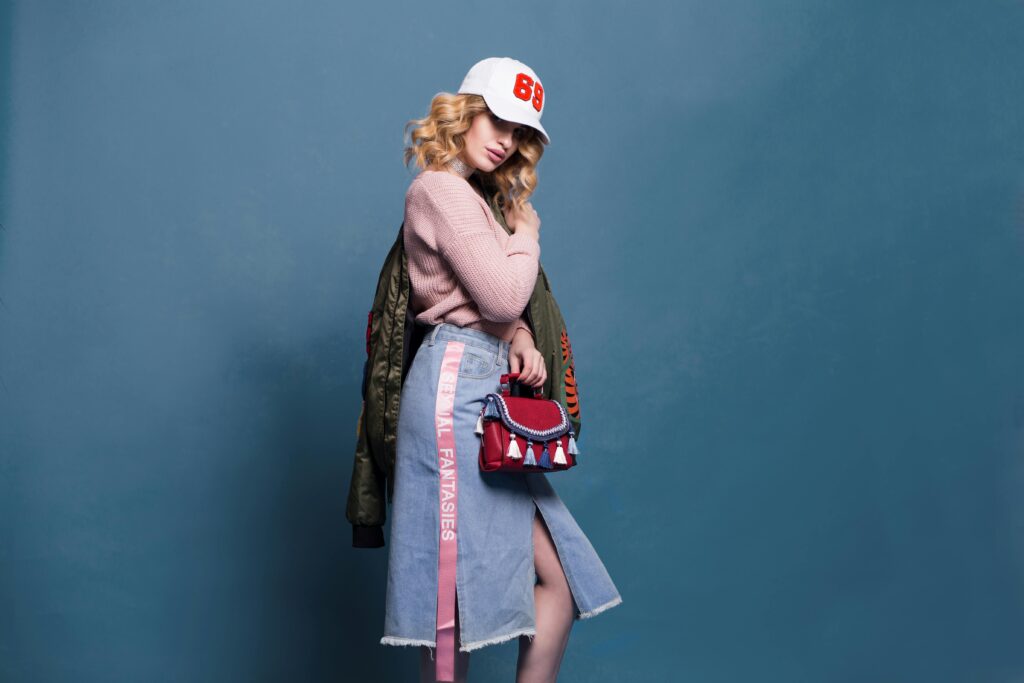 Inicio Trendy fashion model poses in a stylish studio setting, showcasing a chic outfit with accessories.